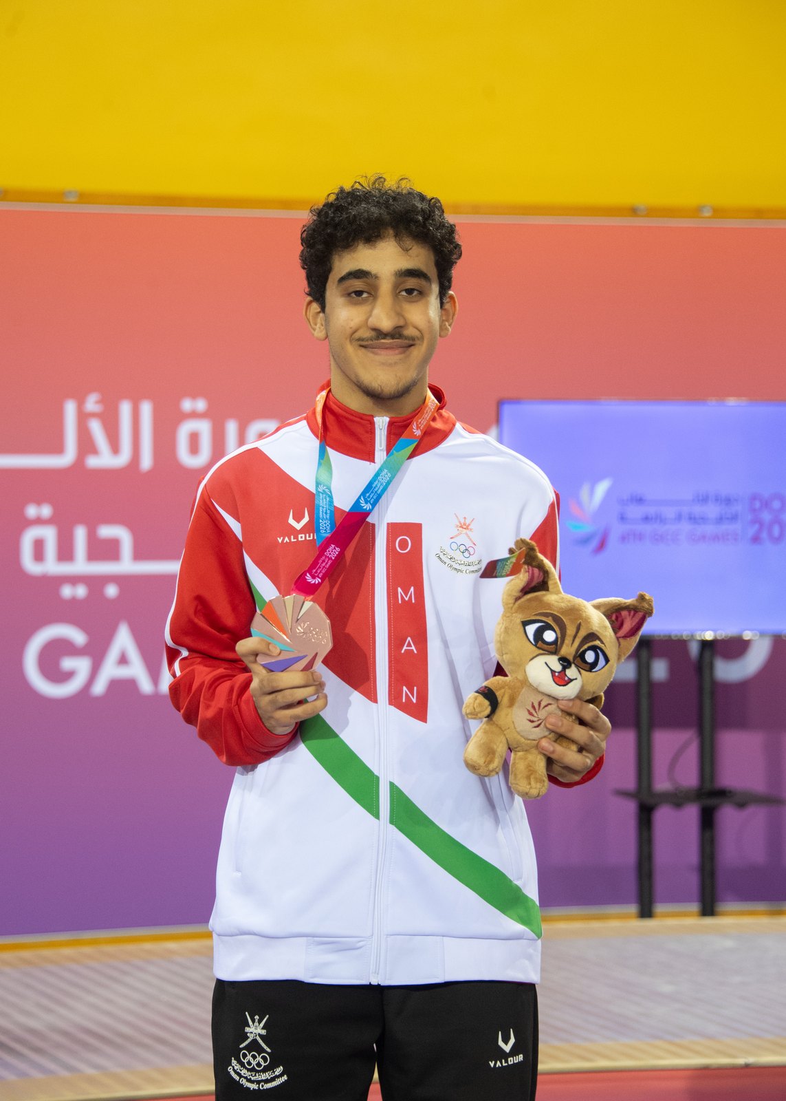 Ali Al Busaidi on the men's individual foil podium receiving his bronze medal at the 4th GCC Games in Doha